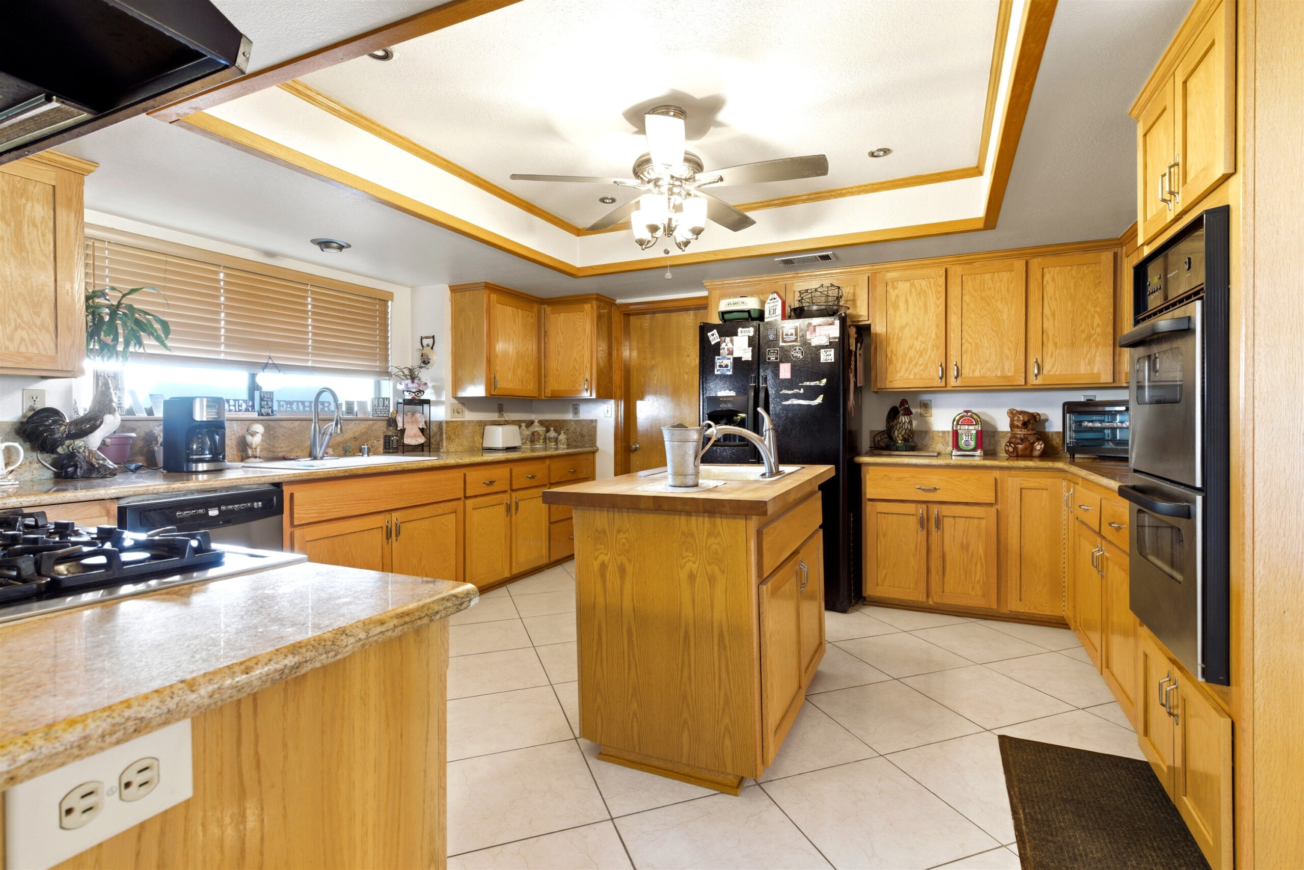 Kitchen with granite counters, island, gas cooktop and double ovens at 11468 Kiowa Rd Apple Valley
