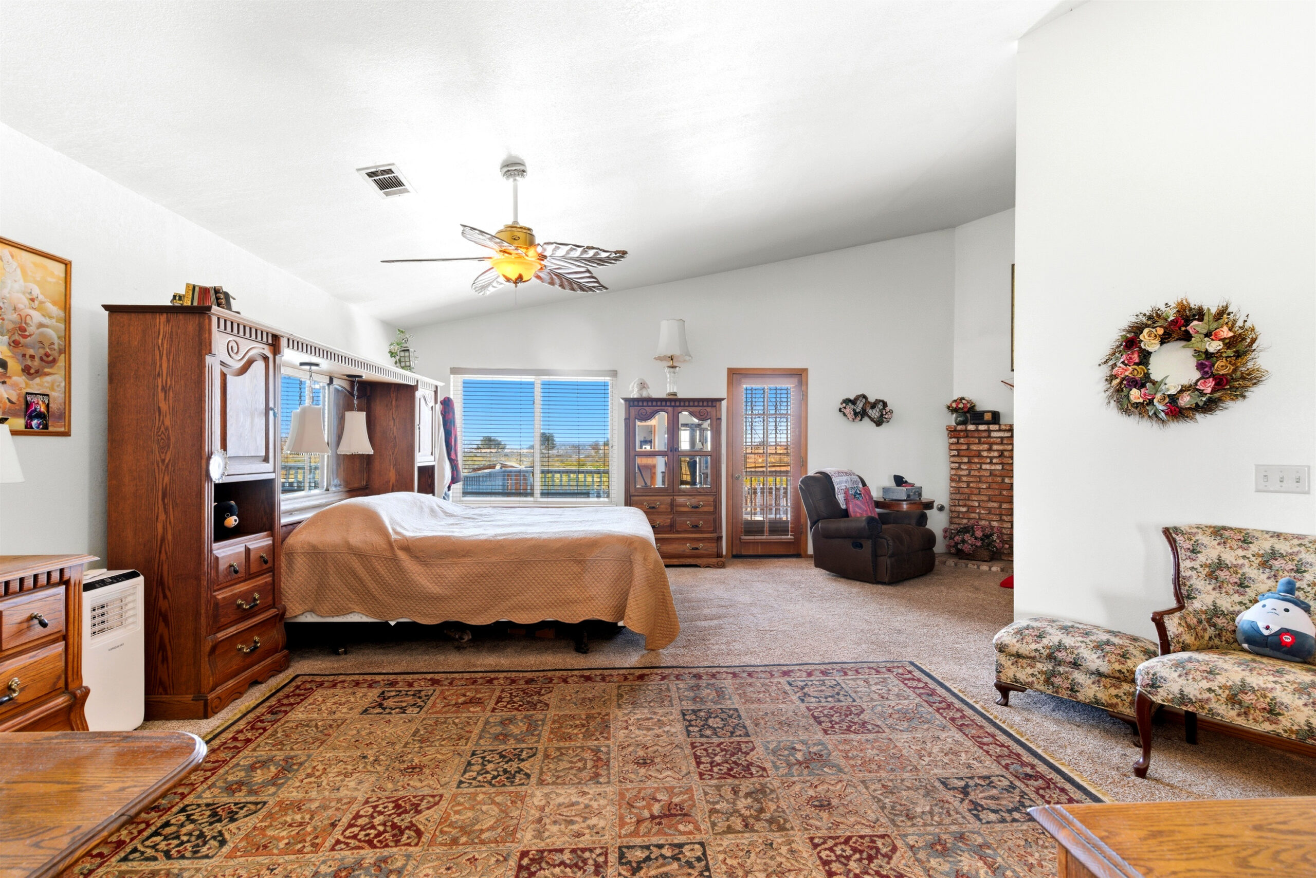 Large primary suite with fireplace and door to balcony at 11468 Kiowa Rd Apple Valley